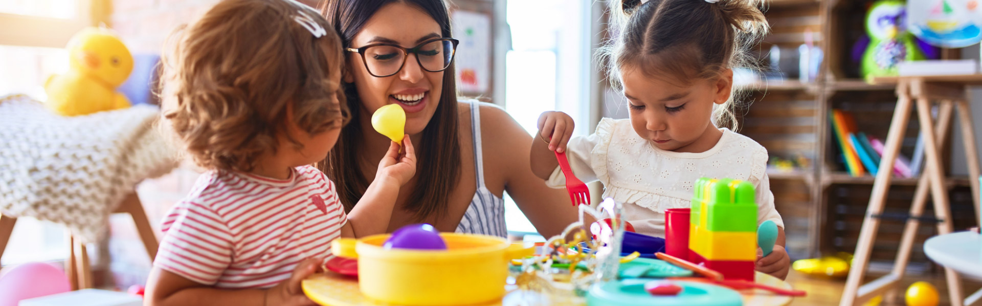 Photo of young woman playing with children