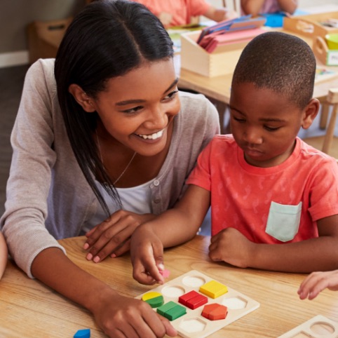 Young woman painting with a pre-schooler