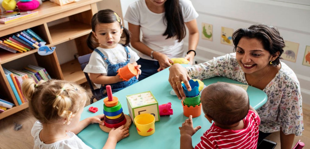 Teachers with children at table